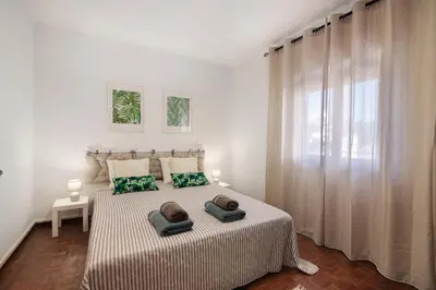 a bedroom with two beds and a dresser and a mirror at Casa Flôr in Albufeira