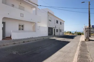 an empty street next to a white building at Casa Flôr in Albufeira
