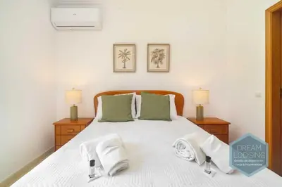 a bedroom with a white bed with towels on it at O Mar - Dream Lodging in Olhos de Água