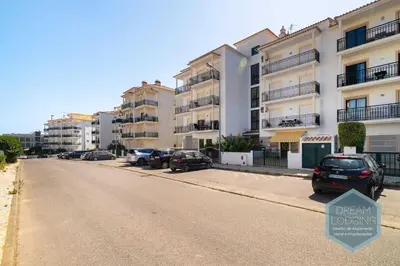 an empty street with cars parked in front of buildings at O Mar - Dream Lodging in Olhos de Água