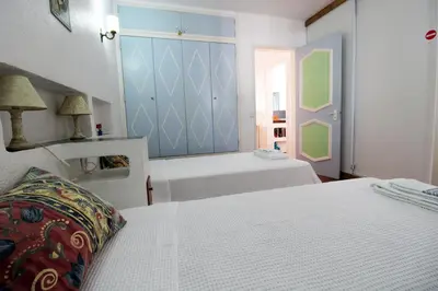 a bedroom with two white beds and a blue wall at V2 - Aldeia do Golfe B2 in Quarteira
