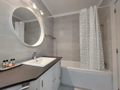 a bathroom with a sink and a tub and a mirror at Vilamouratenis Duck by SAPvillas in Vilamoura