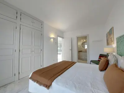 a white bedroom with a large bed and a window at Vilamouratenis Duck by SAPvillas in Vilamoura
