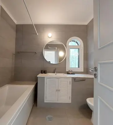 a bathroom with a tub and a sink and a mirror at Vilamouratenis Duck by SAPvillas in Vilamoura