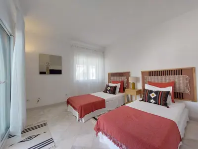 a hotel room with two beds with red sheets at Vilamouratenis Duck by SAPvillas in Vilamoura