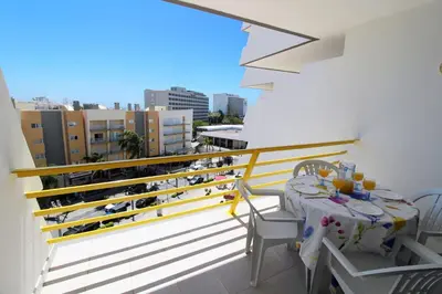 a balcony with a table and chairs and a view of a city at Al-Charb Retreat by SAPvillas in Quarteira