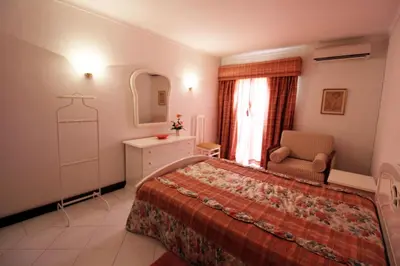 a bedroom with a bed and a chair and a mirror at Al-Charb Retreat by SAPvillas in Quarteira
