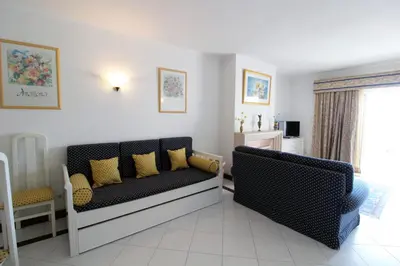 a living room with a couch with yellow pillows at Al-Charb Retreat by SAPvillas in Quarteira