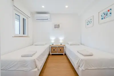 two beds in a room with white walls at Terra Alba in Olhos de Água