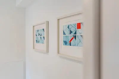 two pieces of art hanging on a white wall at Terra Alba in Olhos de Água