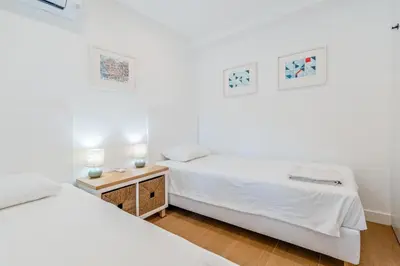 a bedroom with two beds and a night stand with two lamps at Terra Alba in Olhos de Água