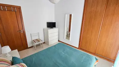 a living room with a large turquoise rug at T1 in Albufeira near Alfamar Hotel in Albufeira