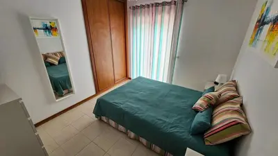 a small bedroom with a bed with a window at T1 in Albufeira near Alfamar Hotel in Albufeira