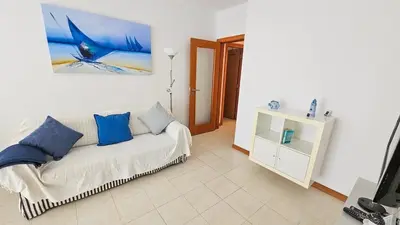 a living room with a white couch and blue pillows at T1 in Albufeira near Alfamar Hotel in Albufeira