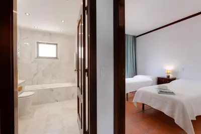 a bathroom with a bed and a tub and a toilet at Beachtime - Oura Beach Apartment in Albufeira
