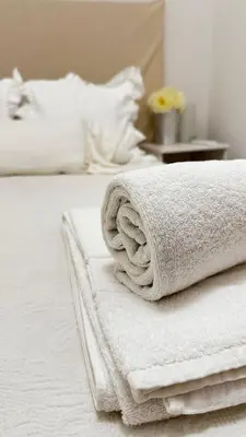 a pile of towels sitting on top of a bed at Tenis, Golf e Mar in Quarteira