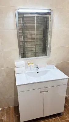 a bathroom with a white sink and a window at Tenis, Golf e Mar in Quarteira