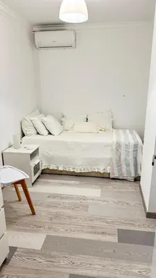 a white bedroom with a bed and a wooden floor at Tenis, Golf e Mar in Quarteira