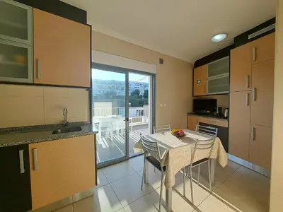 a kitchen with a table and a view of a balcony at Apart SEA and OLD TOWN VIEWS in Albufeira