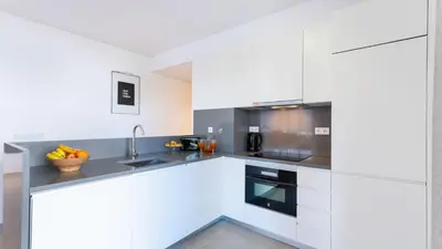a kitchen with white cabinets and a sink at Terrazza Beach & Golf in Quarteira