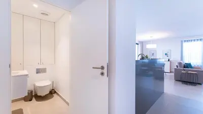 a white room with a toilet and a living room at Terrazza Beach & Golf in Quarteira