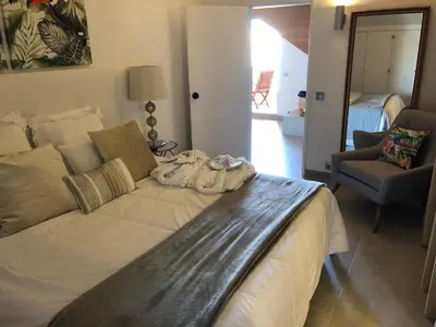 a large bed in a room with a couch and a chair at Beach Apartment Marina Vilamoura in Vilamoura