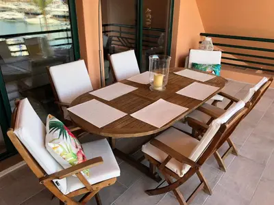 a wooden table and chairs on a balcony at Beach Apartment Marina Vilamoura in Vilamoura