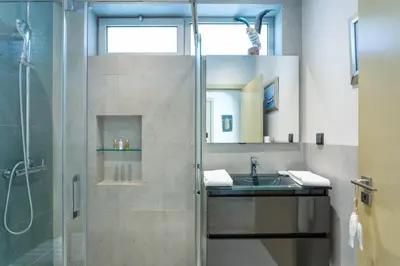 a bathroom with a shower and a sink and a mirror at Deluxe Ancao in Almancil
