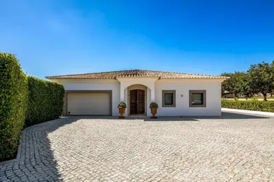 a white house with a garage and a driveway at Villa Zambujal in Boliqueime