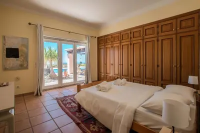a bedroom with a large bed and a large window at Villa Mujeira in Loulé