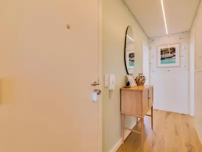 a hallway with a door and a mirror at Penthouse T4 com Vista Mar em Quarteira in Quarteira