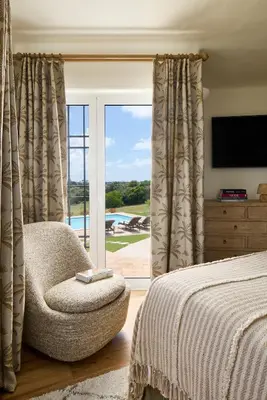 a bedroom with a bed and a chair and a window at Casa Rosa dos Ventos in Guia