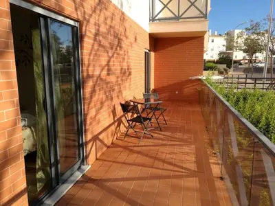 a balcony with two chairs and a table on a brick wall at Luxury ground-floor appartment 5 stars, 2 bedrooms, 2 bathrooms, Free Wifi in Albufeira