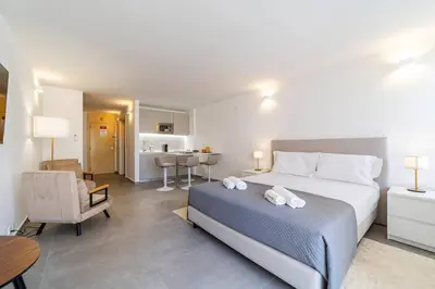 a bedroom with a bed and a living room at Downtown Apartment - BE by HelloVacations in Albufeira