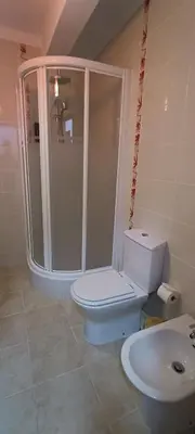a bathroom with a toilet and a shower and a sink at Faro Station Eleven Guest House in Faro