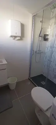 a bathroom with a shower and a toilet at Faro Station Eleven Guest House in Faro