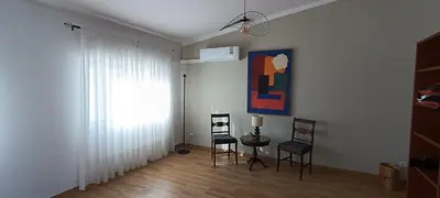 a living room with a table and chairs and a painting at Faro Station Eleven Guest House in Faro