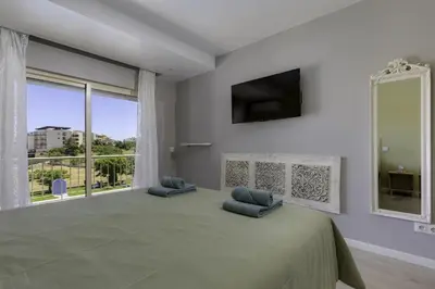 a bedroom with a large bed and a large window at CORCOVADA SUNSET Just 5 min from the Strip in Albufeira