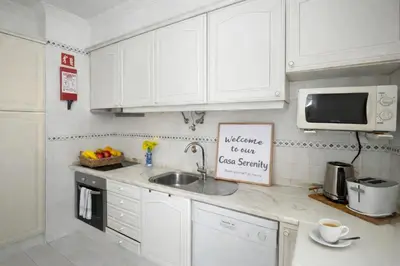 a kitchen with white cabinets and a sink at Casa Sérénity By Calyferias in Guia