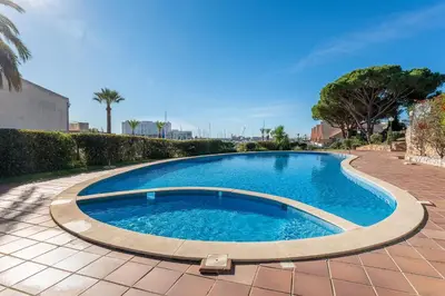 a large swimming pool on a brick patio at Pearl Harbor 3 BDR Flat VLM Marina by LovelyStay in Quarteira