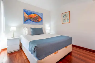 a bedroom with a bed and a painting on the wall at Pearl Harbor 3 BDR Flat VLM Marina by LovelyStay in Quarteira