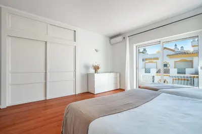 a bedroom with a bed and a large window at Luxe Penthouse, BBQ, hot spa, games, ocean view - By Seareen in Albufeira