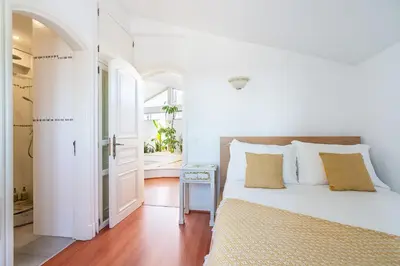 a white bedroom with a bed with a view of the ocean at Luxe Penthouse, BBQ, hot spa, games, ocean view - By Seareen in Albufeira