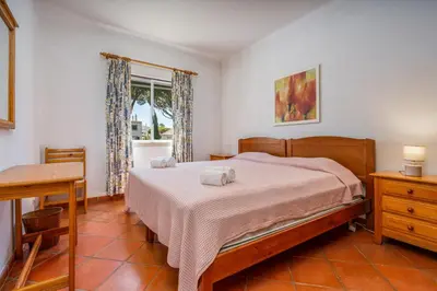 a bedroom with a bed and a desk and a window at Pool Apartment Vilamoura near Old Village in Quarteira