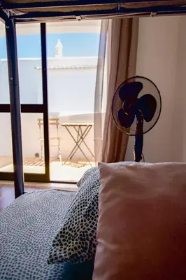a bedroom with a bed with a pillow and a window at Fernando Pessoa Villa in Faro