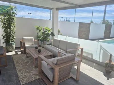 a patio with a couch and a table and chairs at Fernando Pessoa Villa in Faro
