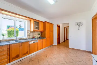 a kitchen with wooden cabinets and a window at Villa Castelo by Algarve Holidays in Albufeira