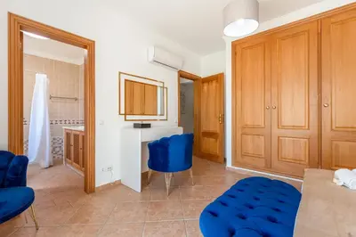 a living room with blue chairs and a table at Villa Castelo by Algarve Holidays in Albufeira