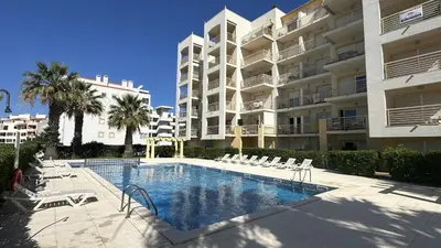 a swimming pool in front of a large apartment building at Wave by Check-in Portugal in Albufeira