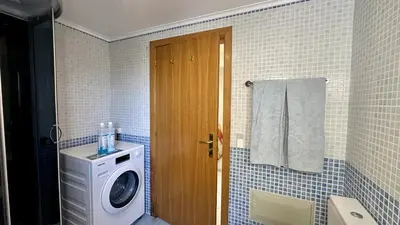 a bathroom with a washing machine and a washer at Wave by Check-in Portugal in Albufeira